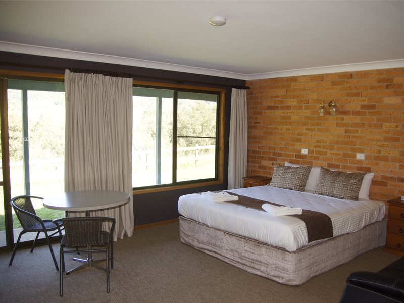 Spa Suite king bed beside a wide window onto the gardens